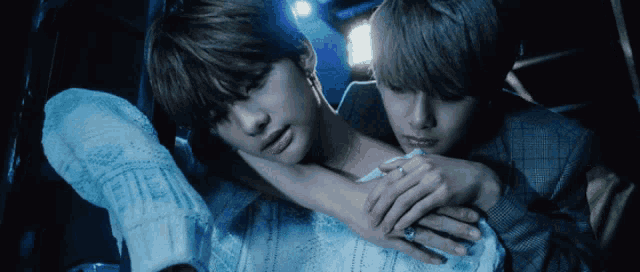 two young men are hugging each other in a car