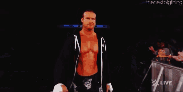 a wrestler named dolph ziggler is standing in front of a crowd holding a sign that says zimmerman is a baby