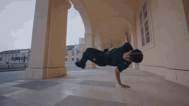 a man doing a handstand under an archway