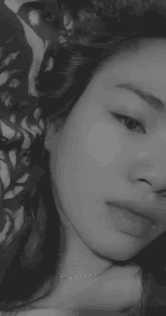 a black and white photo of a woman 's face with her eyes closed .