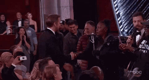 a man is kissing another man in front of a crowd of people at an event .