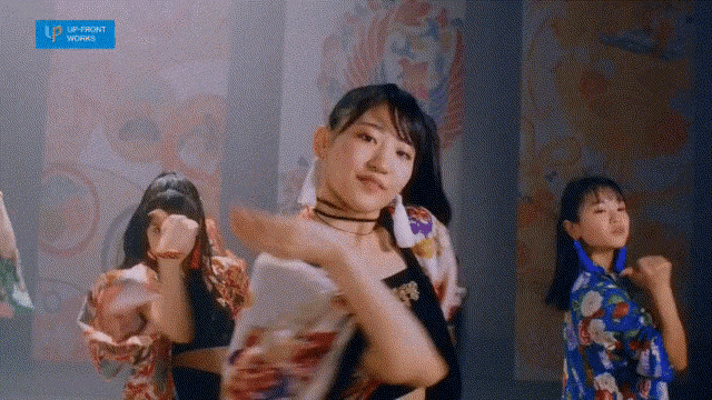 a group of young women are dancing in front of a sign that says up front works
