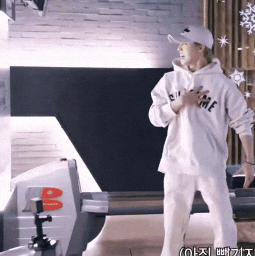 a man wearing a white hoodie that says supreme on the front