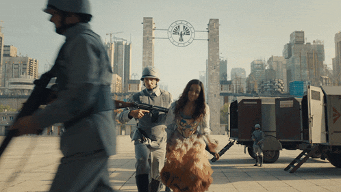 a woman in a dress is being escorted by soldiers in front of a clock that says ' liberty ' on it