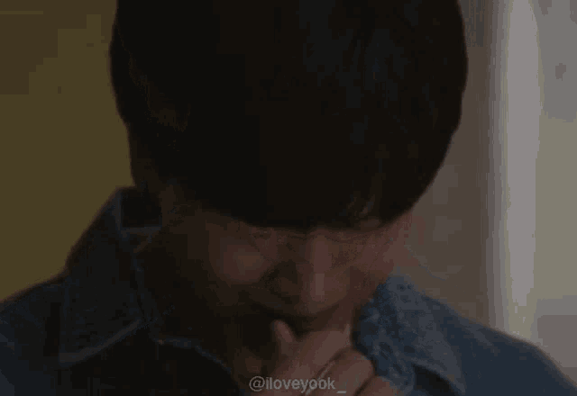 a close up of a man 's face with his hand on his chin .