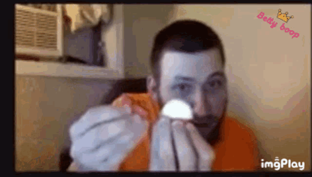 a man with a beard is holding a piece of paper in his hand .