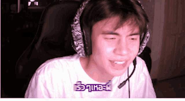 a young man wearing headphones and a white shirt with the word equals on the front