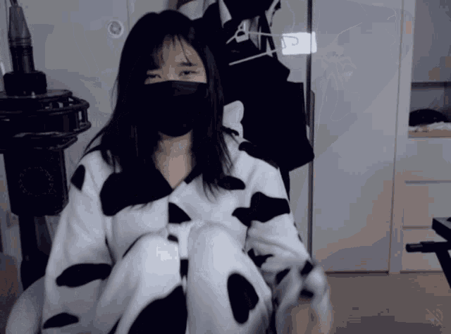 a woman wearing a mask and a cow print shirt