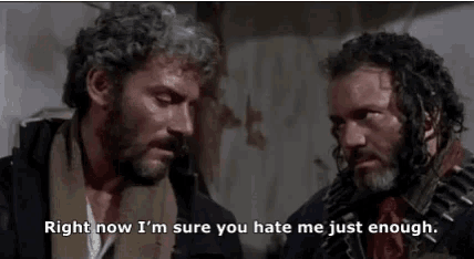 two men with beard and curly hair are standing next to each other and talking .