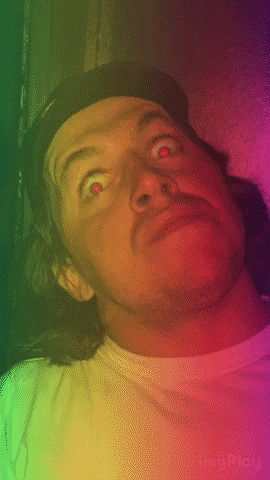 a man wearing a hat and a white shirt with a rainbow background