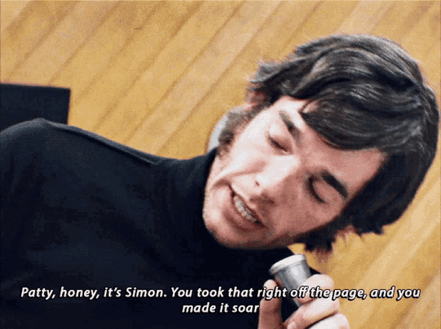 a man is holding a microphone and says patty honey it 's simon