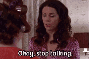 a woman with curlers in her hair is talking to another woman and says okay , stop talking .