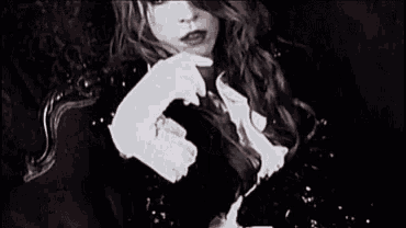 a woman with long hair is covering her mouth with her hand .