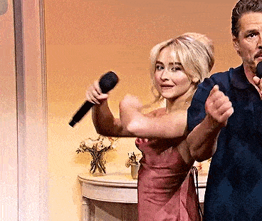 a man and a woman are standing next to each other holding microphones and dancing .