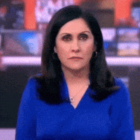 a woman is wearing a blue shirt and earrings