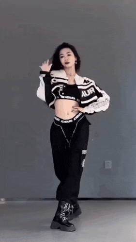 a woman in a crop top and black pants is dancing