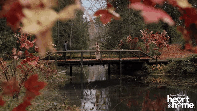 a couple walking across a bridge with the words heart & me on the bottom right