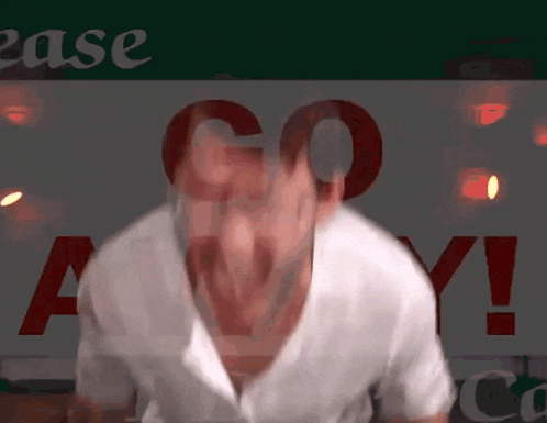 a man in a white shirt stands in front of a sign that says go any !