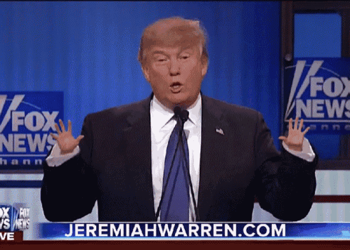 a man in a suit and tie is giving a speech in front of a fox news sign