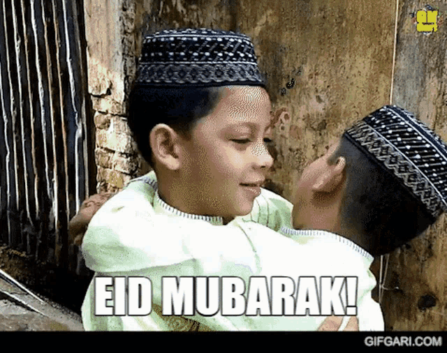 two young boys hugging each other with the words eid mubarak on the bottom right