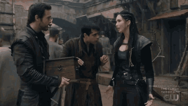 a man is holding a wooden box while a woman talks to him in a scene from the flash
