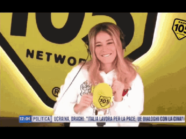 a woman wearing headphones and holding a yellow object with 105 on it