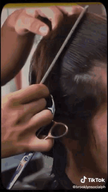 a woman is getting her hair cut by a hairdresser .
