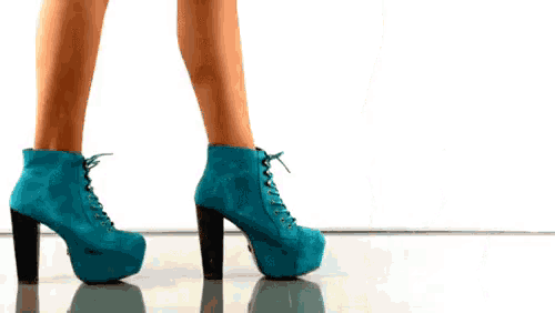 a woman is wearing a pair of blue platform boots
