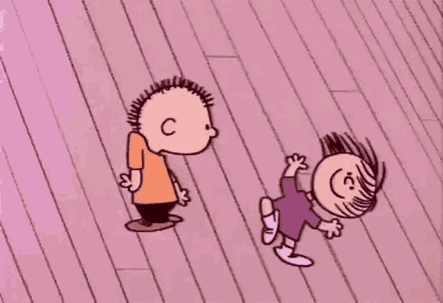 a boy and a girl are laying on a pink floor
