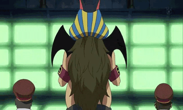 a cartoon character with a bat winged hat on his head stands in front of a green wall