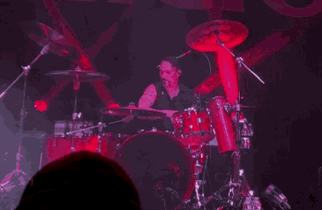 a man is playing drums in front of a sign that says " religion "
