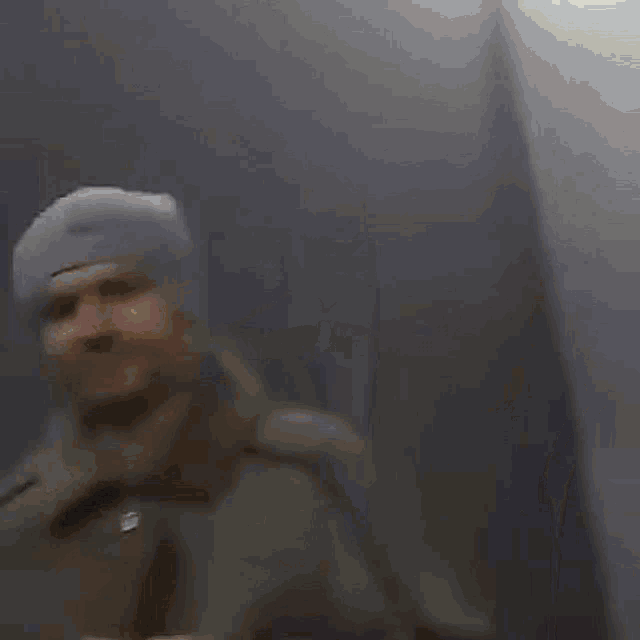 a man is standing in front of a door in a dark room talking on a cell phone .