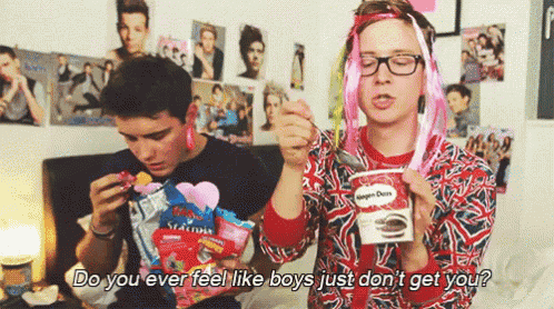 two boys are eating candy and one of them is holding a cup of ice cream and a bag of candy .