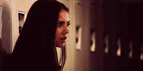 a woman standing in front of a row of lockers with the words nina dobrevstan at the bottom