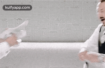 two men in suits are fighting over a piece of paper in a room .