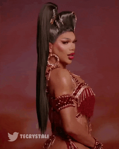 a woman with a ponytail is wearing earrings and a red dress with a twitter logo in the corner