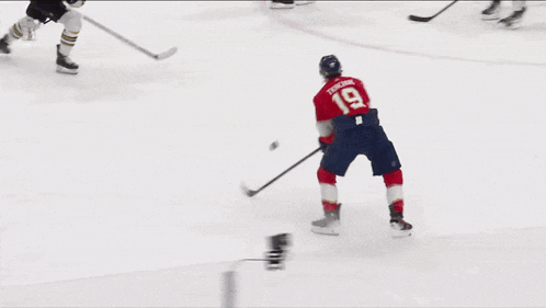 a hockey player with the number 19 on his jersey stands on the ice