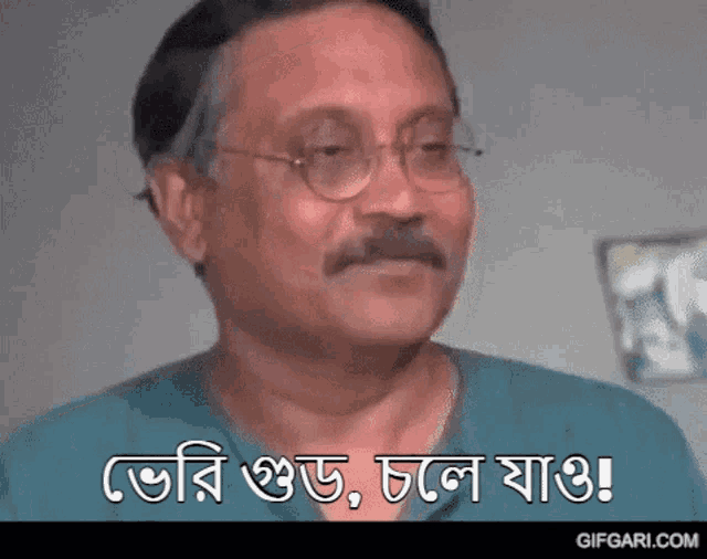 a man with glasses and a mustache is making a funny face and saying a phrase in a foreign language .