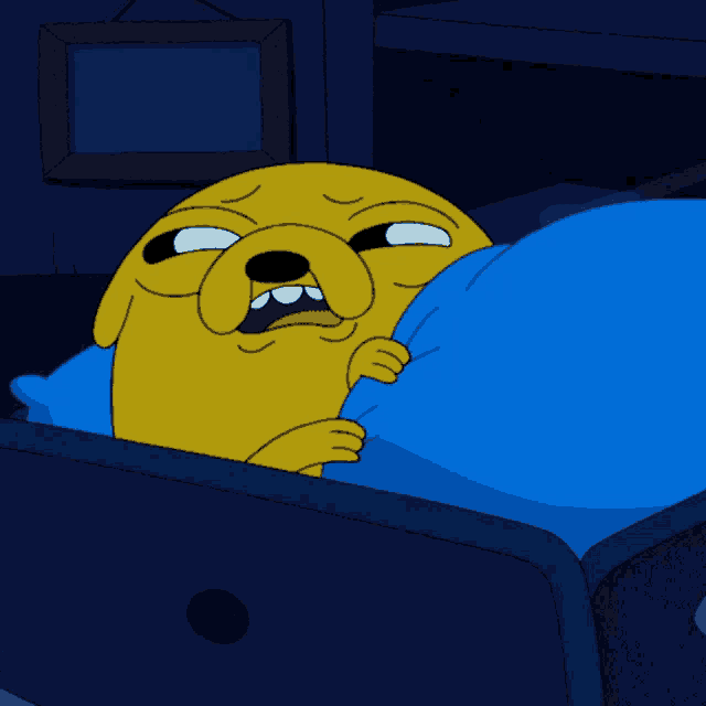 a cartoon character is laying in bed with a blue blanket