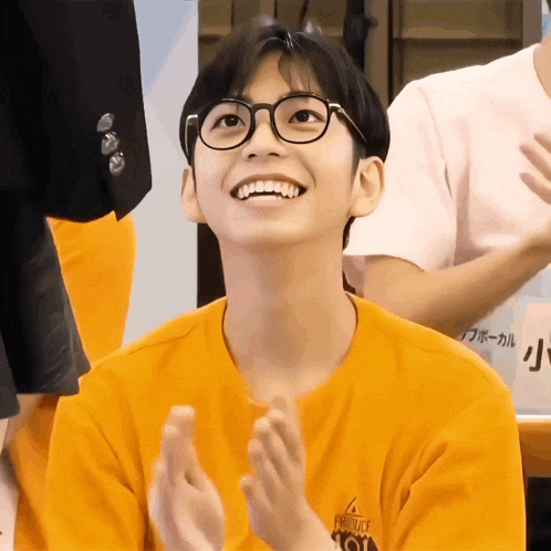 a young man wearing glasses and an orange shirt with the word produce on it