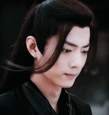 a close up of a man with long hair