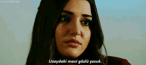 a close up of a woman 's face with the words uzaydaki mavi gozlu çocuk written below her