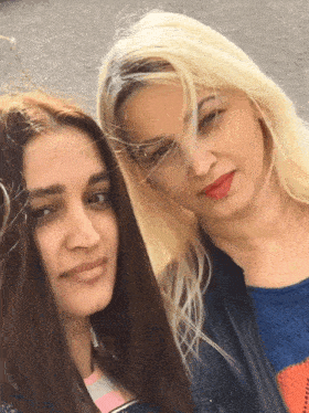 two women are posing for a picture and one has red lipstick on