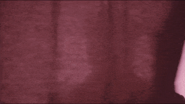 a man with a beard is standing in front of a pink background