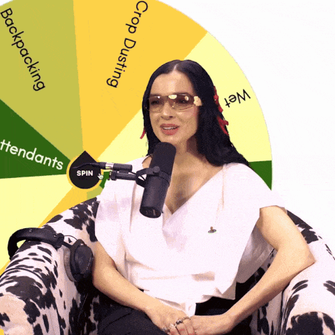 a woman sitting in a chair with a microphone in front of a wheel that says backpacking