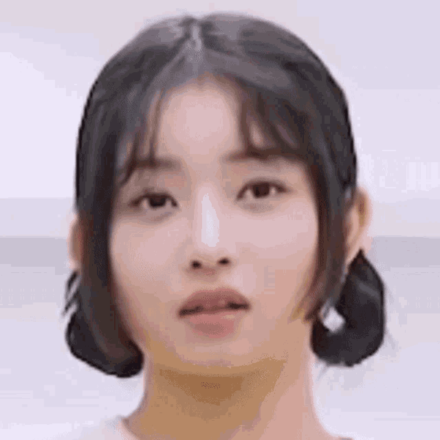 a close up of a woman 's face with her mouth open and her hair in pigtails .