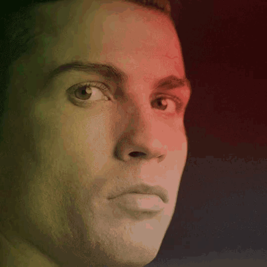 a close up of a man 's face with a red and green gradient