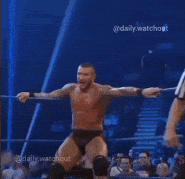 a man in red shorts is kicking another man in the face in a wrestling match .