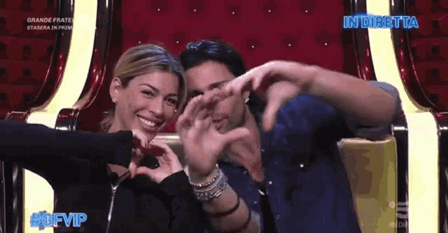 a man and a woman are making a heart shape with their hands in front of a sign that says #gfvip