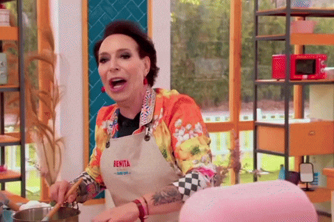 a woman wearing an apron that says benita is cooking in a kitchen